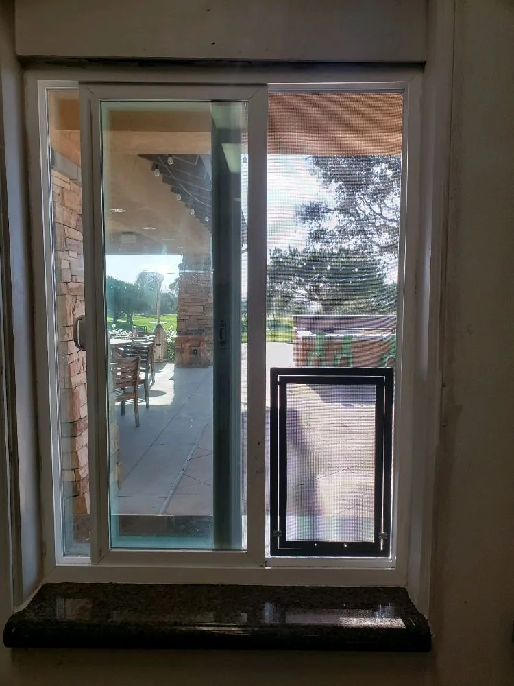 A screen door with a pet-access opening at the bottom