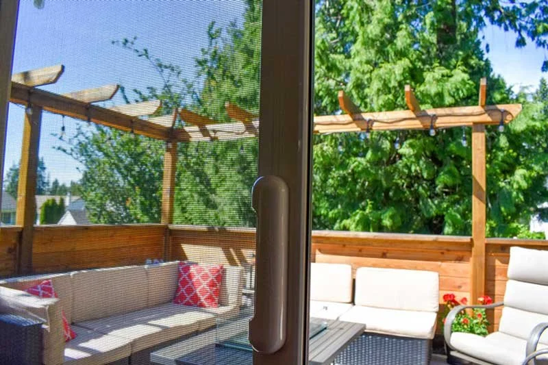 Screen doorway looking onto a sunny garden patio