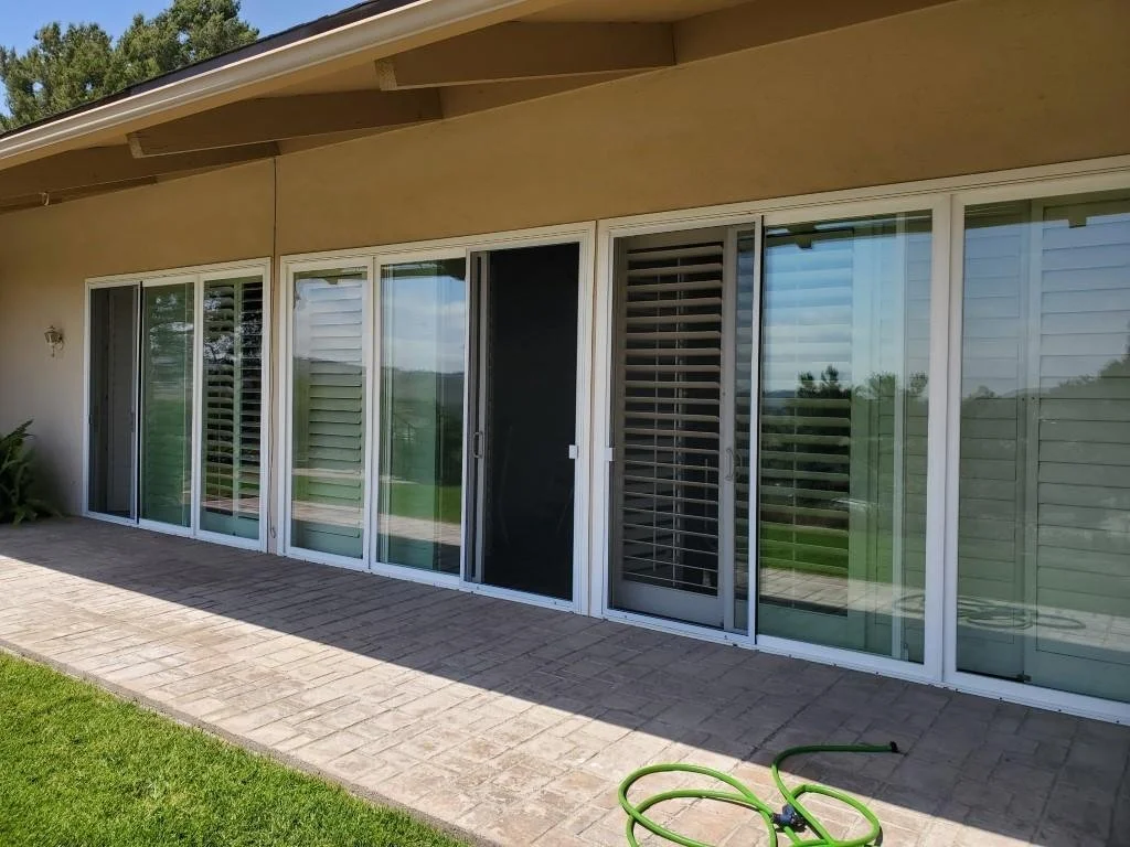 Custom sliding screen doors along the back patio of a home